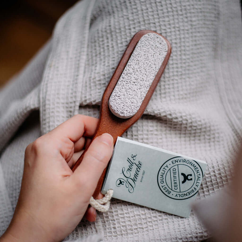 Hand mit Bimssteninbürste