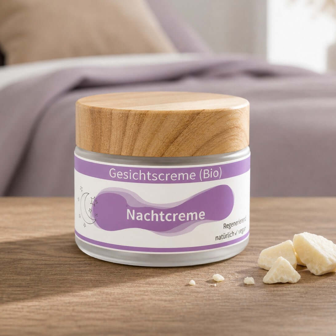 Nachtcreme (Bio) in einem Glasbehälter auf einem Tisch, mit Zutaten daneben.